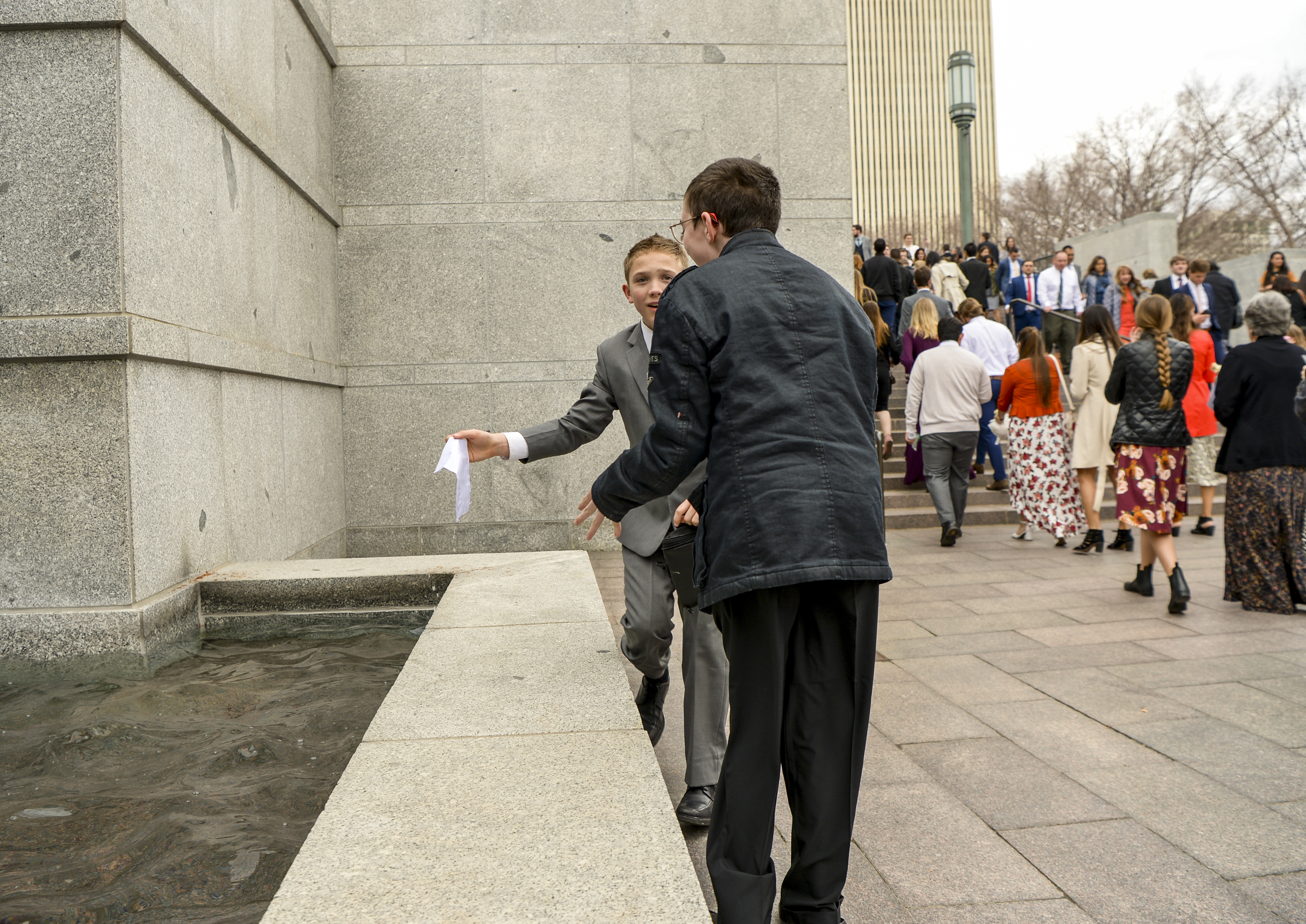 Leah Hogsten | The Salt Lake Tribune A young boy who accidentally dropped his ticket from the building's bridge retrieves it from the fountain prior to the afternoon session of the 189th Annual General Conference of The Church of Jesus Christ of Latter-day Saints, April 6, 2019 in Salt Lake City. 