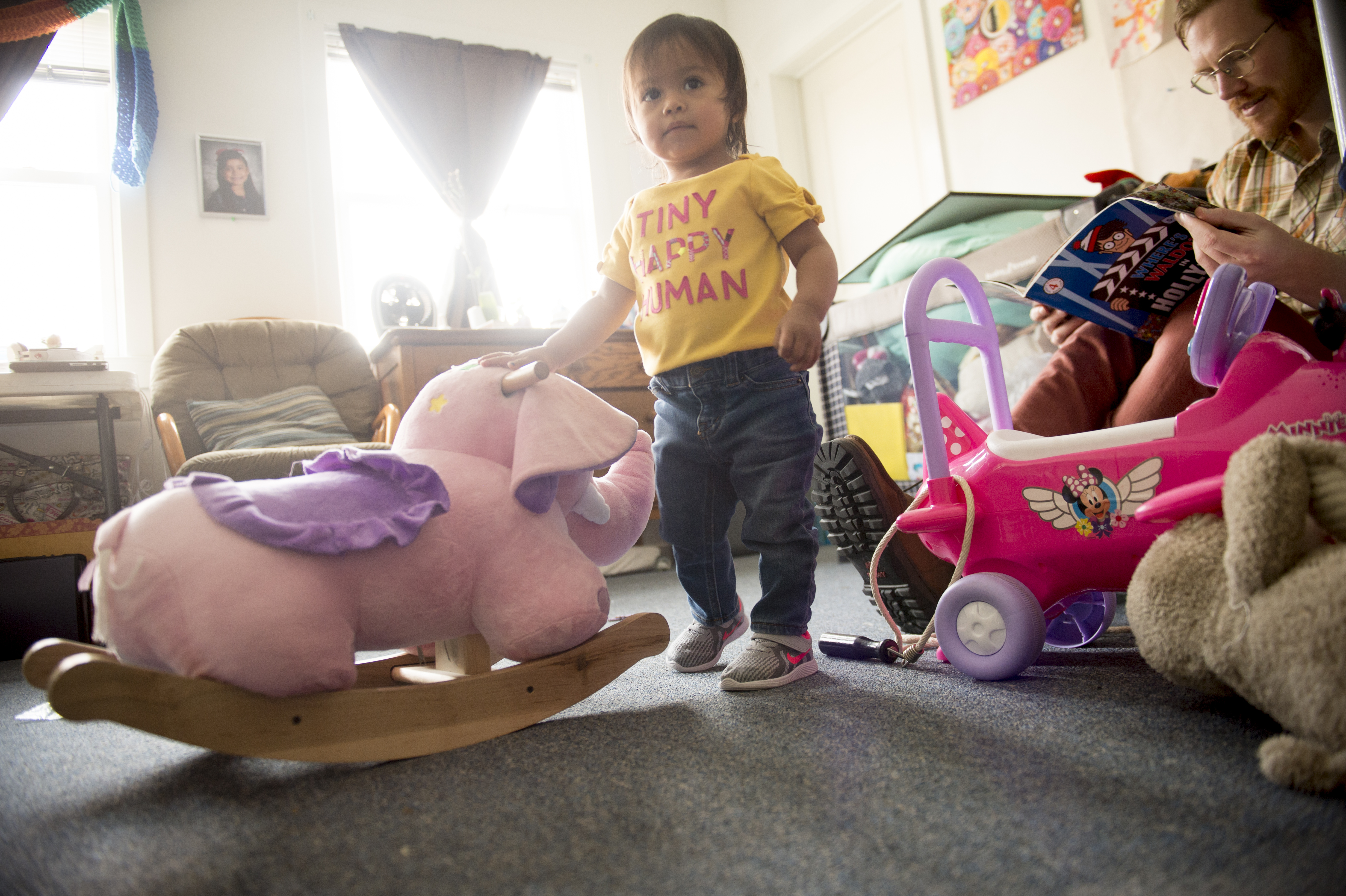 (Jeremy Harmon | The Salt Lake Tribune) Seventeen-month-old Bella plays with toys as volunteer Easton Smith looks at a book in the Chavez family room at the First Unitarian Church on 1300 East in Salt Lake City on Dec. 14, 2018.