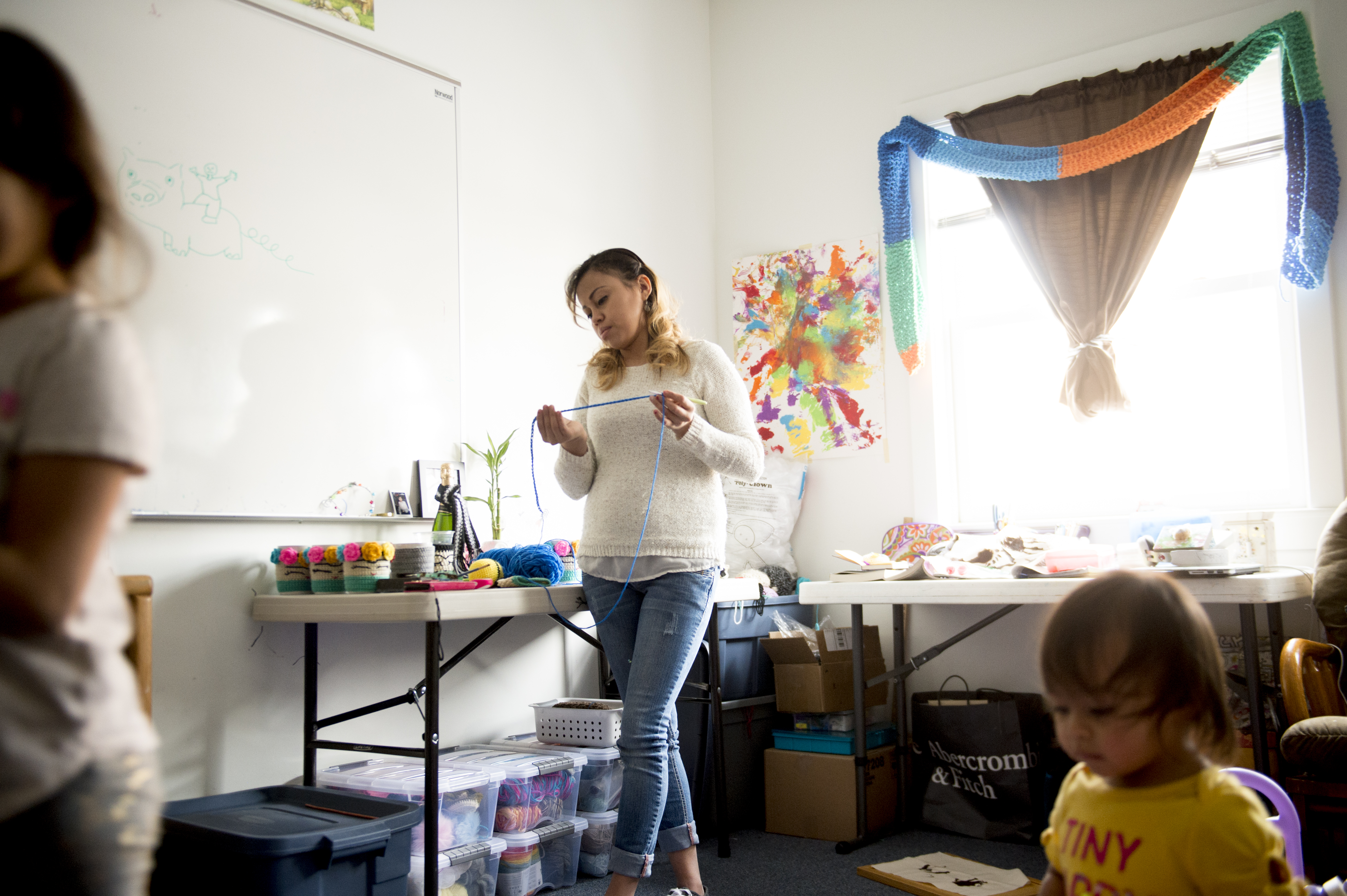 (Jeremy Harmon | The Salt Lake Tribune) Vicky Chavez inspects a piece of yarn as her daughters play in their room at the First Unitarian Church on 1300 East in Salt Lake City on Dec. 14, 2018. Chavez makes a little bit of extra money by crocheting items for friends and family.