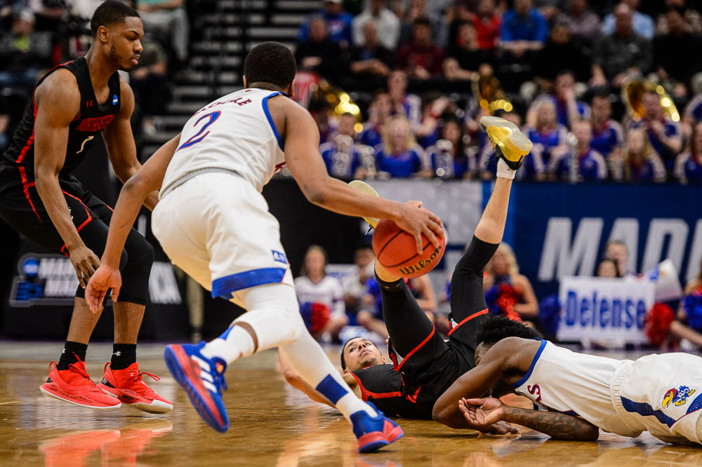 (Trent Nelson | The Salt Lake Tribune) Kansas Jayhawks guard Charlie Moore (2) picks up a turnover as Kansas faces Northeastern in the 2019 NCAA Tournament in Salt Lake City on Thursday March 21, 2019.