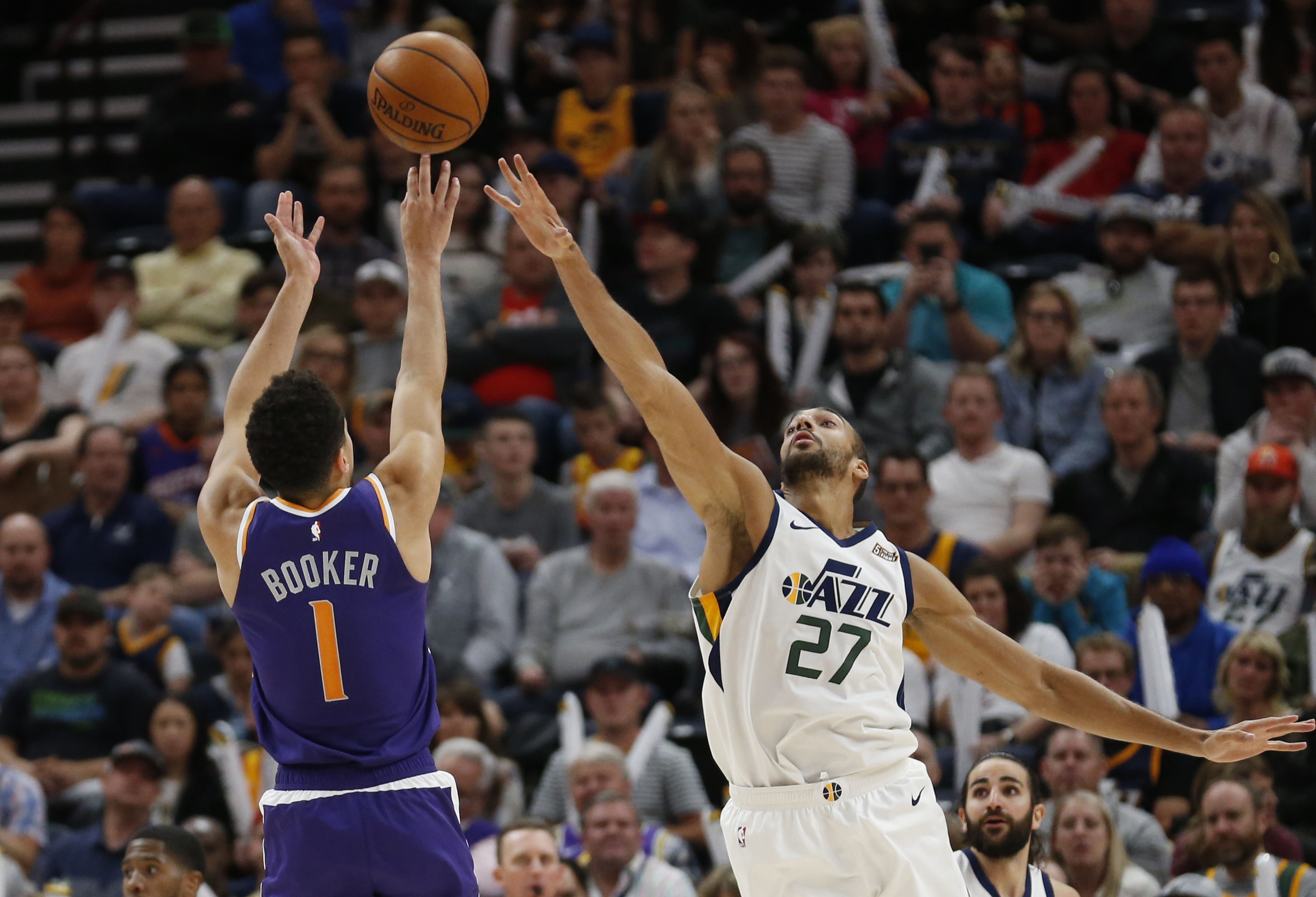 Phoenix Suns guard Devin Booker (1) shoots as Utah Jazz center Rudy Gobert (27) defends during the second half of an NBA basketball game Monday, March 25, 2019, in Salt Lake City. (AP Photo/Rick Bowmer)