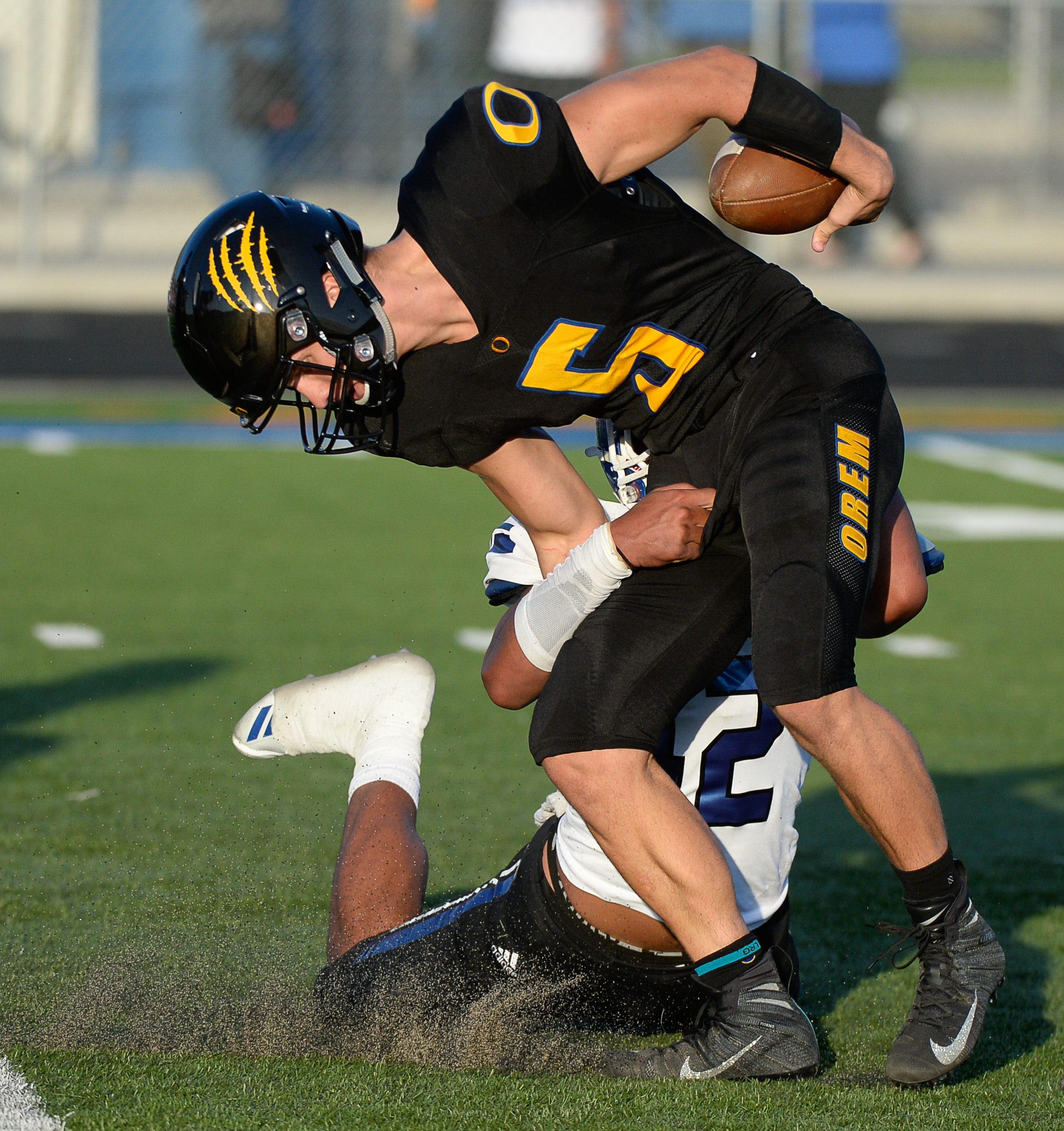 (Francisco Kjolseth | The Salt Lake Tribune) Orem's quarterback Cooper Legas is taken down by Bingham's Sione Fotu in the first half of the game Thursday, Aug. 16, 2018 in Orem.