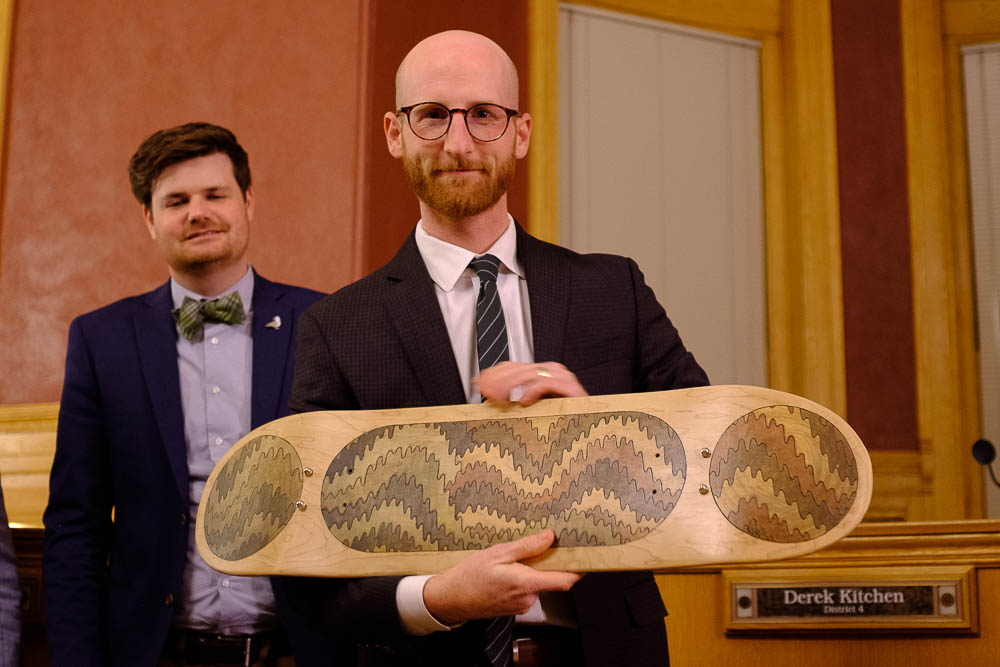 (Trent Nelson | The Salt Lake Tribune) Outgoing Salt Lake City Council Member Derek Kitchen is given a piece of art, a skateboard by artist Evan Jed, at the council meeting on Tuesday Nov. 27, 2018. At rear is Council Member Chris Wharton.