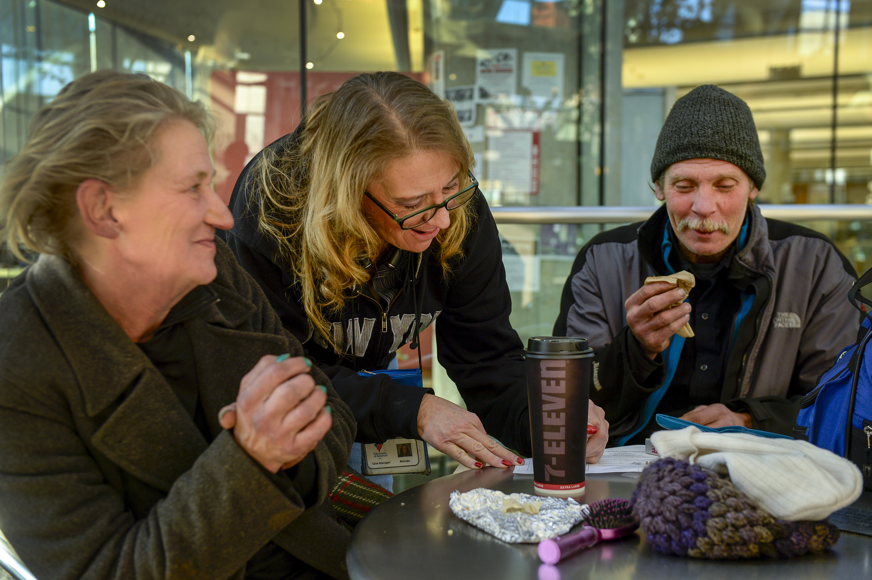 (Leah Hogsten | The Salt Lake Tribune) Katherine Barrett, 54, and her husband Ron Barrett, 55, share a laugh with Rhonda Robison, center, a homeless outreach program worker for the Volunteers of America stationed at the Salt Lake Library, as Robison writes out a clothing voucher for the two. The Barretts, who are homeless, have three months to find housing through a Shelter Plus Care housing voucher through the Salt Lake City Housing Authority.