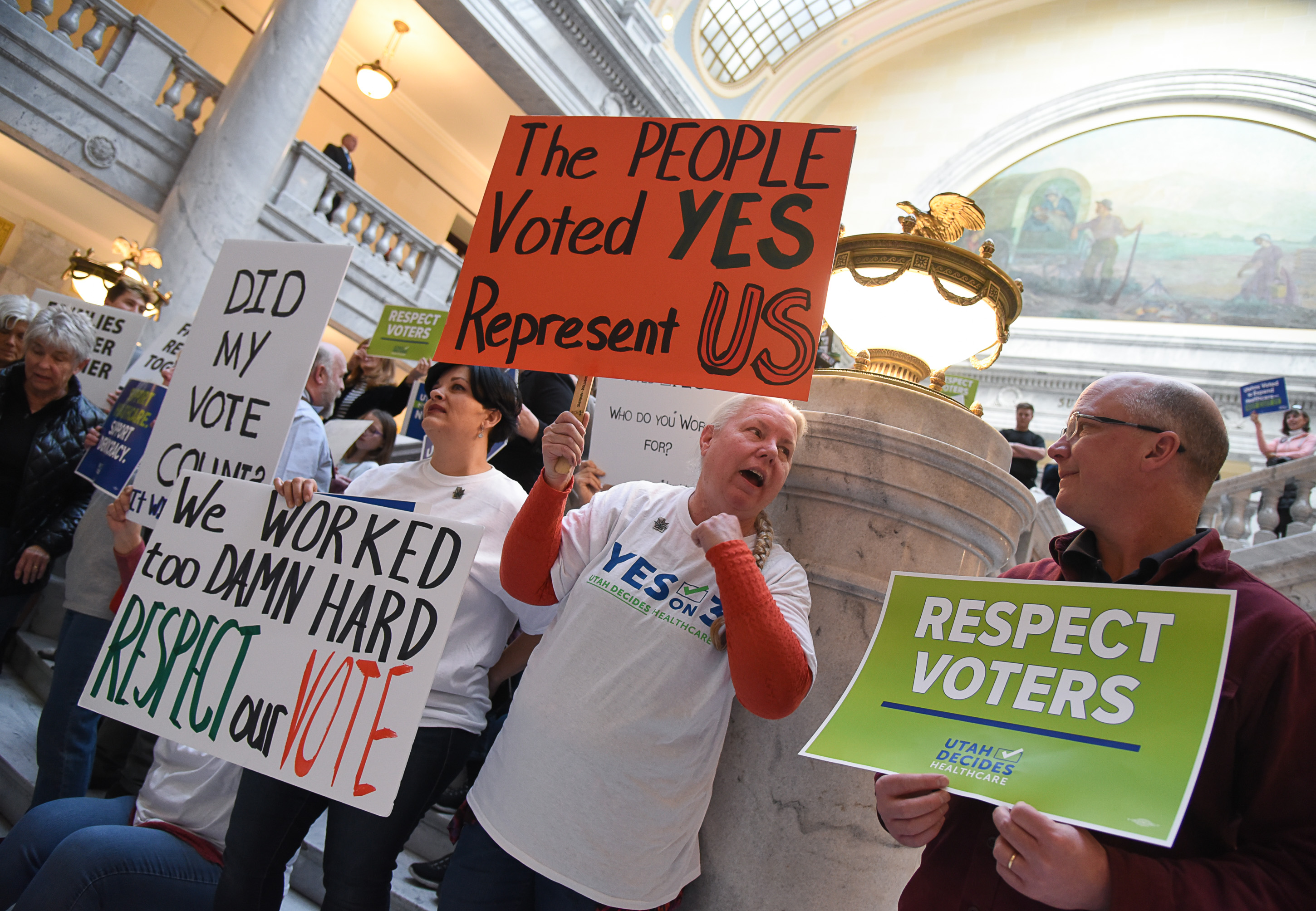 (Francisco Kjolseth | The Salt Lake Tribune) Tiffany Malo, Pam Harrison and John Armstrong, from left, join over 300 demonstrators as they fill the Capitol rotunda on Monday, Jan, 28, 2019, on the first day of the Legislative session to rally in support of protecting Proposition 3, the Medicaid Expansion law recently passed by voters.
