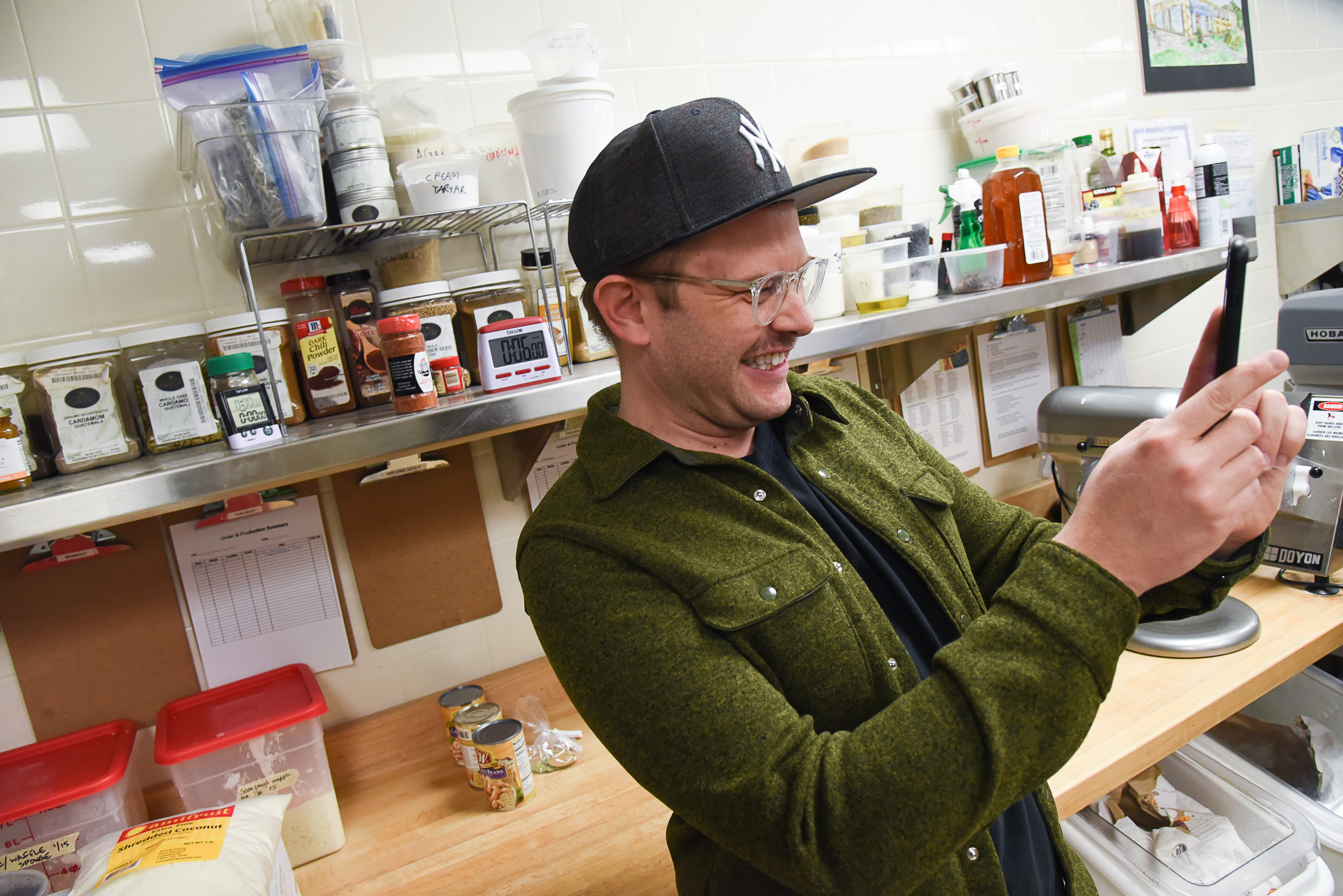 (Francisco Kjolseth | The Salt Lake Tribune) Joshua Black, Director of Communications at Salt Lake Acting Company smiles as he documents actress Betsy West learning how to frost a cake as she prepares for an upcoming role of a Southern Baptist bakery owner in North Carolina faced with a request to bake a cake for a gay couple getting married for SLAC'S production of "The Cake." A self admitted baking novice, West, in search of better authenticity in portraying her role received a one-on-one lesson from the chef's at Flourish Bakery.