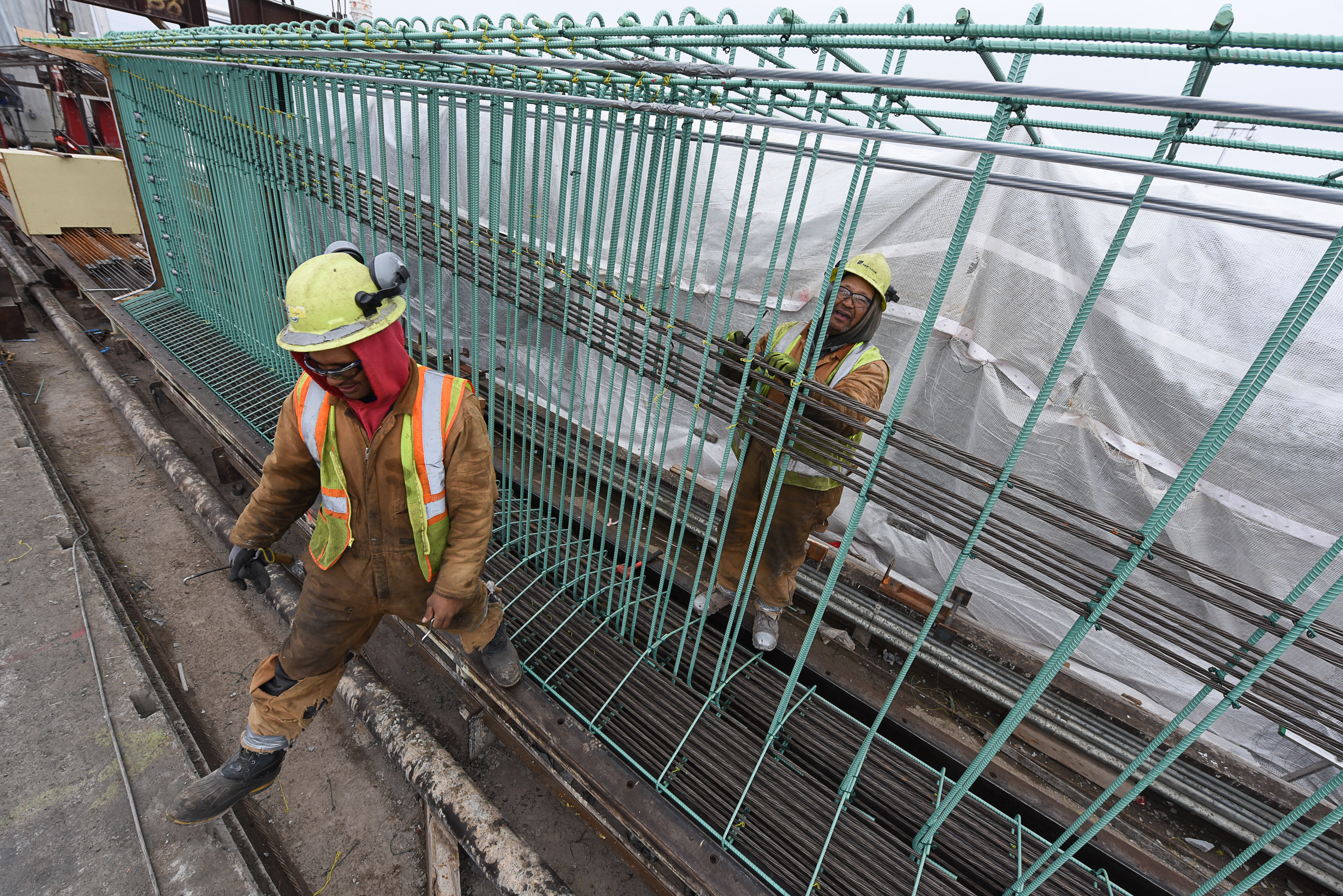 (Francisco Kjolseth | The Salt Lake Tribune) Crew members Meli Kaufausi, left, and Simone Katoa work on the extensive structural integrity of a bridge beam at Forterra Structural Precast in Kearns on Tuesday, Dec. 11, 2018. UDOT is in the process of placing some of the world's largest-ever bridge beams, with the same design, along the technology corridor in Lehi later this week.