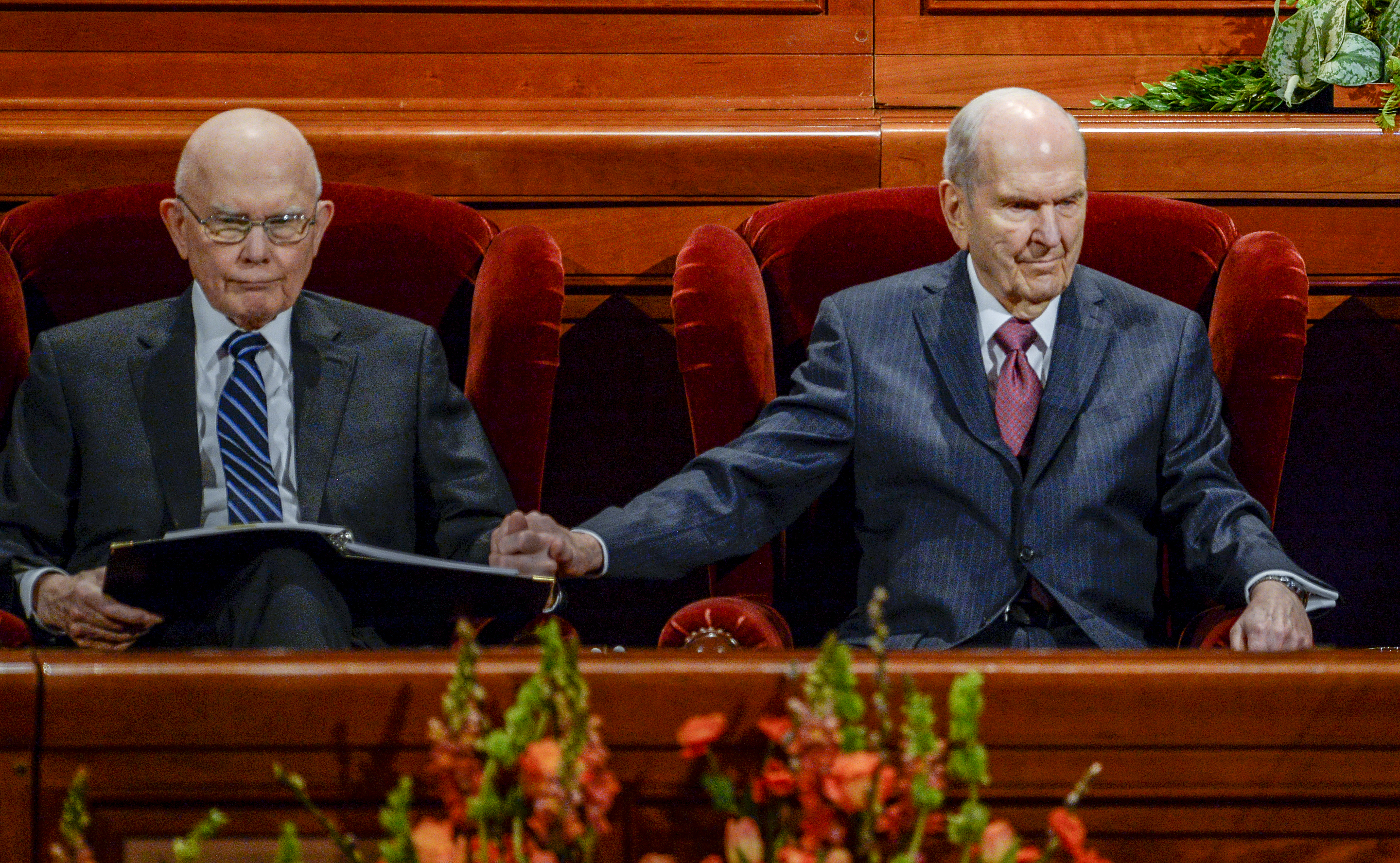 (Leah Hogsten | The Salt Lake Tribune) l-r President Russell M. Nelson reaches out to squeeze the hand of President Dallin H. Oaks during the morning session of the189th Annual General Conference of The Church of Jesus Christ of Latter-day Saints in Salt Lake City. President Henry B. Eyring is at right.