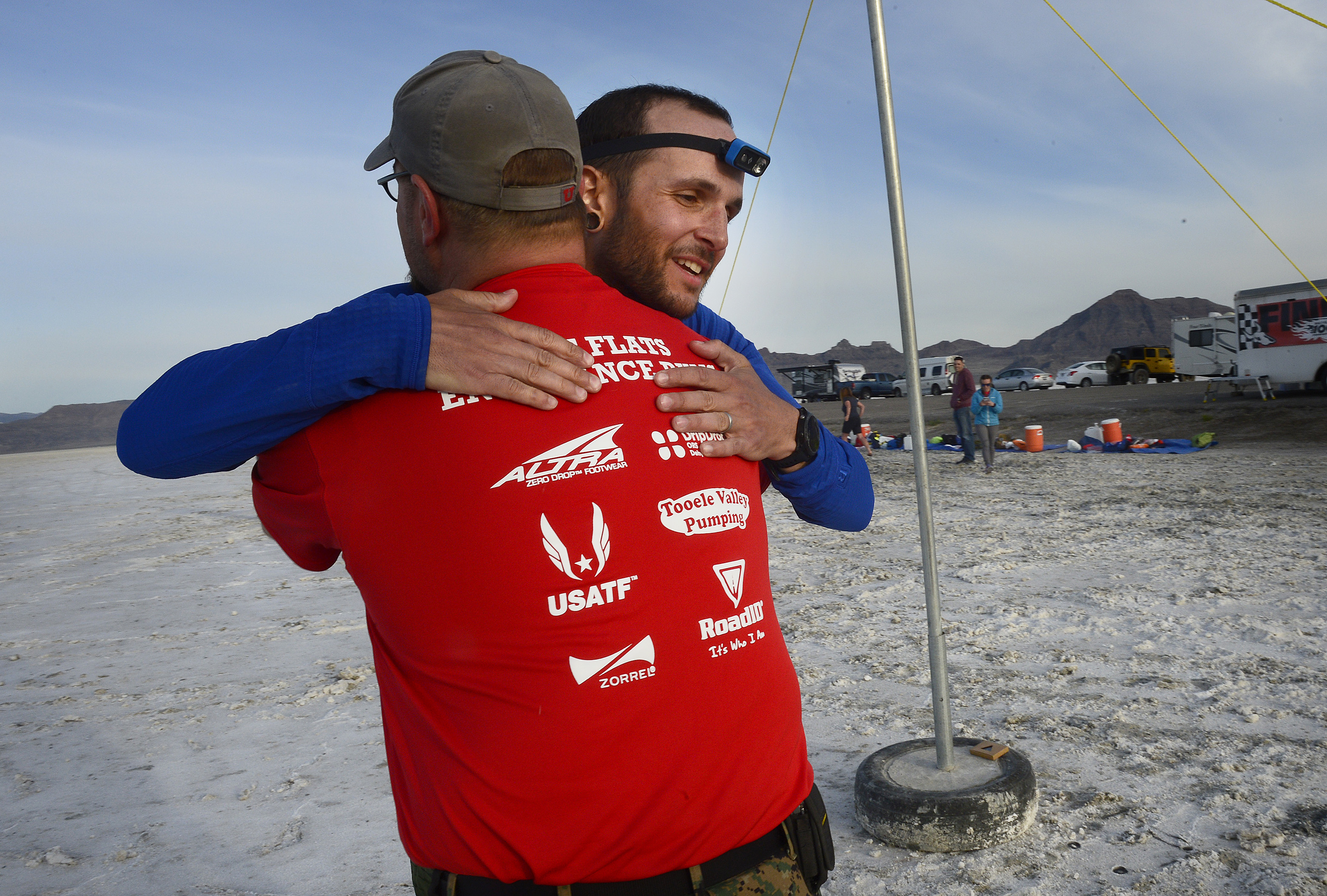 (Scott Sommerdorf | The Salt Lake Tribune) Alex Doolan gets a hug after crossing the finish line in 8th place at the Salt Flats 100 Endurance Run, Saturday, May 5, 2018. Doolan finished in 8th place.