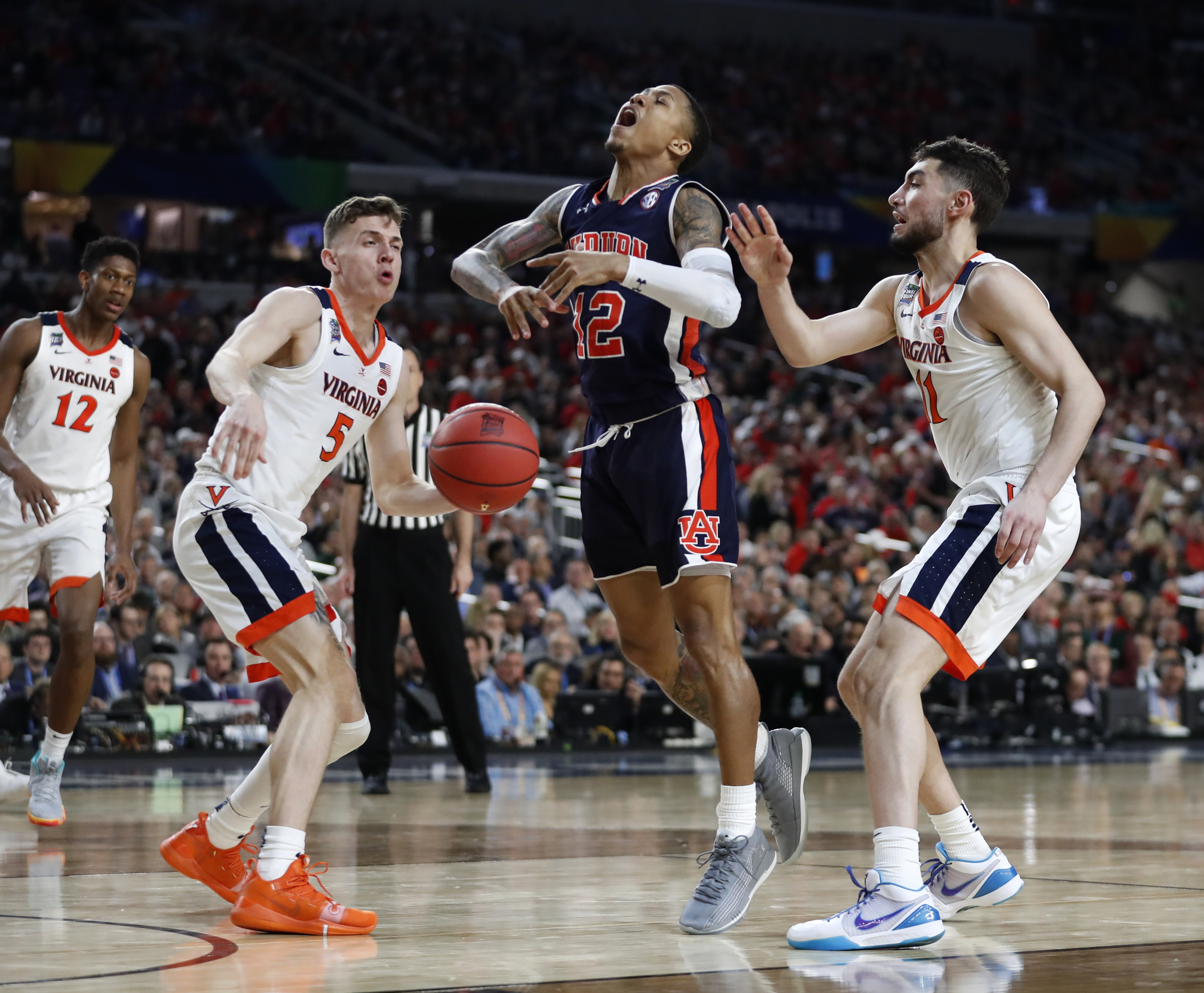 Auburn guard J'Von McCormick, center, drives to the basket between Virginia's Kyle Guy, left, and Ty Jerome, right, during the second half in the semifinals of the Final Four NCAA college basketball tournament, Saturday, April 6, 2019, in Minneapolis. (AP Photo/Jeff Roberson)