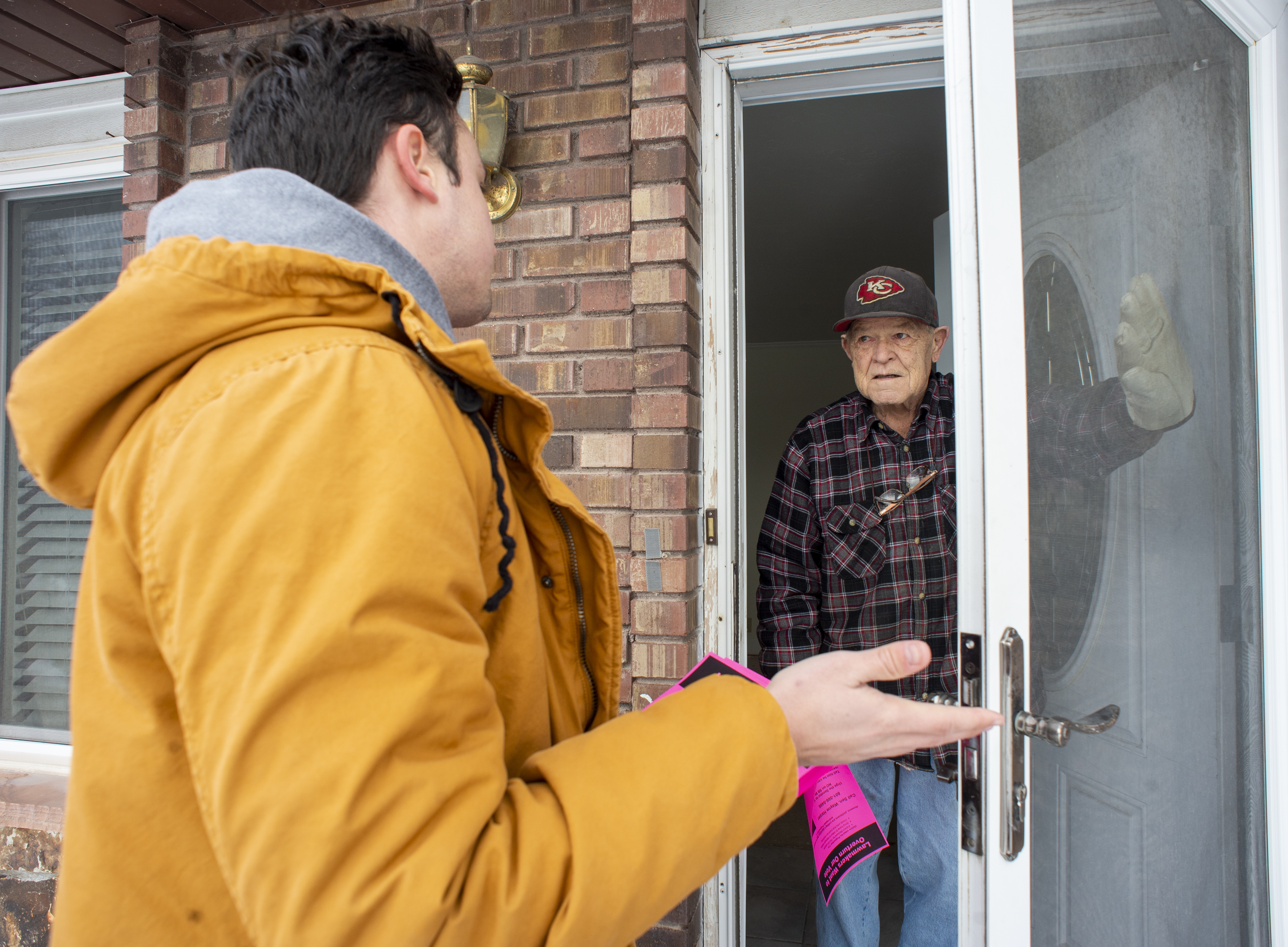 (Rick Egan | The Salt Lake Tribune) Keaton Hill talks to Ron Bishop, as he goes door to door in a neighborhood in Taylorsville with other supporters of the fuller Medicaid expansion, urging residents to call their senator, Saturday, Feb. 9, 2019. 